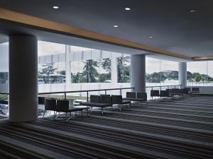 a waiting area in a building with chairs and windows at Pullman Kuching in Kuching +128 photos