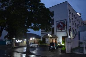 a building with a car parked in front of it at SG Palace Hotel in Taubaté