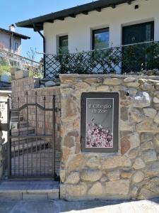 um sinal numa parede de pedra em frente a uma casa em IL CILIEGIO DI ZOE em Cerro Lago Maggiore