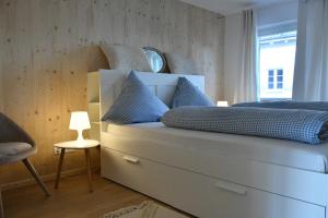 a bedroom with a large white bed with blue pillows at Chalet in Ühlingen-Birkendorf