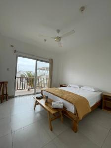 a bedroom with a large bed and a large window at Samana Hostal, Puerto Engabao in Engabao