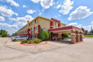 Ramada by Wyndham Oklahoma City Airport North في مدينة اوكلاهوما: مبنى فيه سيارة متوقفة في موقف للسيارات