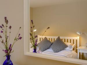 a mirror reflection of a bed with pillows at Rose Cottage in Poynings