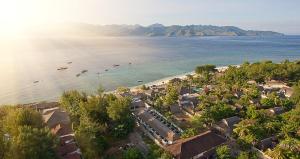 eine Luftansicht auf einen Strand mit Booten im Wasser in der Unterkunft Scallywags Resort in Gili Trawangan