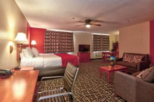 a hotel room with a bed and a living room at Ramada by Wyndham Oklahoma City Airport North in Oklahoma City