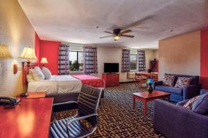 Ramada by Wyndham Oklahoma City Airport North في مدينة اوكلاهوما: غرفه فندقيه بسرير واريكه