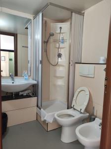 La salle de bains est pourvue de toilettes, d'un lavabo et d'une douche. dans l'établissement Albergo Caffaro, à Gênes