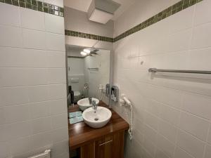 a bathroom with a sink and a mirror at Landhotel Traube in Baden-Baden