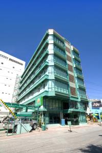 a tall green building with a lot of windows at New Dawn Pensionne House in Cagayan de Oro