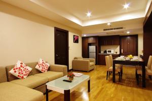uma sala de estar com um sofá e uma mesa em The Ninth Place Serviced Residence em Bangna