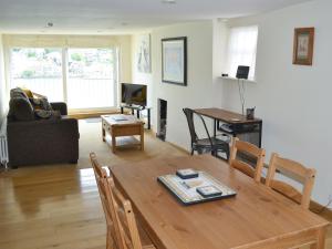 a living room with a wooden table and a couch at Nelson Steps 3 in Kingswear