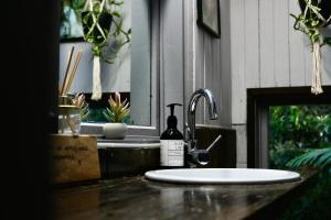 a sink with a bottle of wine next to a sink at Ananda Eco House - Eco Rainforest Retreat in Montville