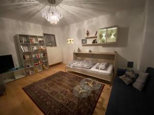 ein Wohnzimmer mit einem Bett und einem Glastisch in der Unterkunft Central City Privatapartment Relax-Inn, Netflix & Sky TV! in Hannover
