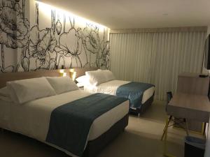 梅爾加的住宿－Hotel Karmel，酒店客房设有两张床,墙上挂有壁画