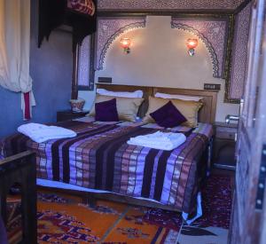 a bedroom with a bed with purple and white sheets at Riad Atlas Panorama in Imlil