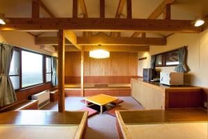 a living room with wooden furniture and a tv at Kuju Kogen Cottage in Taketa