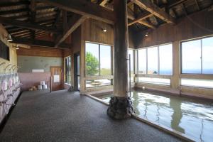 Habitación grande con ventanas grandes y una columna grande. en Kuju Kogen Cottage en Taketa