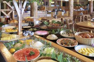 Kuju Kogen Cottage في Taketa: بوفيه مع العديد من أطباق الطعام على طاولة