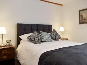 a bedroom with a large bed with pillows on it at Grange Cottage in Winston