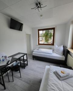 um quarto com uma cama, uma secretária e uma mesa em Zimmerwelt-Ilsfeld em Ilsfeld