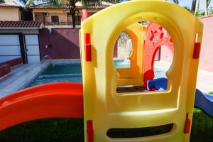 uma casa de brincar de plástico num quintal com piscina em Hotel Rosa da Ilha - Pertinho do Mar com piscina no Guarujá