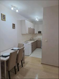 - une cuisine et une salle à manger avec une table et des chaises dans l'établissement Apartman City kvart, à Podgorica