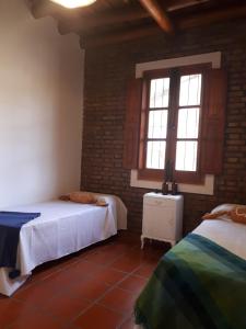 1 dormitorio con 2 camas y ventana en Casa Paula en Las Rabonas
