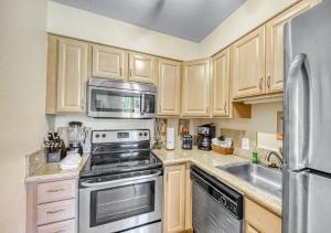 a kitchen with wooden cabinets and stainless steel appliances at Paki Maui by HI in Lahaina