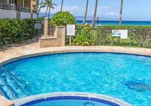 a large swimming pool with the ocean in the background at Paki Maui by HI in Lahaina