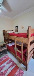 a bedroom with two bunk beds with red sheets at Recanto Primavera in Blumenau