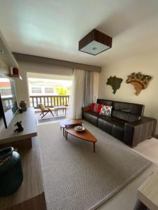 uma sala de estar com um sofá e uma mesa em Buzios Beach Resort Super Luxo Residencial 2501 e 2502 em Búzios