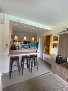 a kitchen with a counter with stools in it at Buzios Beach Resort Super Luxo Residencial 2501 e 2502 in Búzios