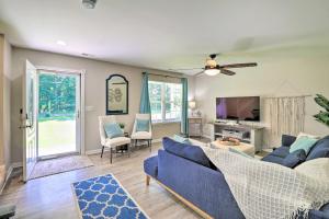 a living room with a blue couch and a tv at Walk to the Beach with Deck, Fireplace, BBQ Grill, Boat Ramp & Office in Chestertown