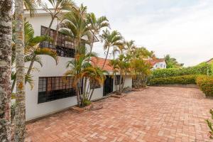 un patio de ladrillo con palmeras frente a un edificio en Amazing Finca House Private Swimming Pool & Air Conditioner, en Melgar