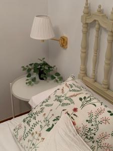 a bed with a pillow and a lamp and a table at Precioso piso recién reformado en Zaragoza in Zaragoza
