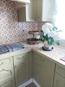 una cocina con encimera y un jarrón de flores en Guibert Home - Appartement spacieux à 20 min de Paris, en Villeneuve-le-Roi