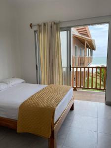 a bedroom with a bed and a balcony with the ocean at Samana Hostal, Puerto Engabao in Engabao