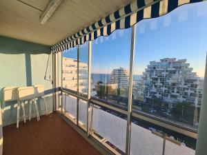 a balcony with chairs and a view of a building at Appartement lumineux avec vue sur mer in La Grande Motte