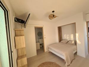a small bedroom with a bed and a bathroom at Appartement lumineux avec vue sur mer in La Grande-Motte