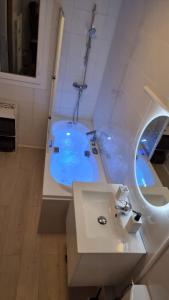Baño blanco con lavabo y espejo en Appartement lumineux avec vue sur mer en La Grande-Motte
