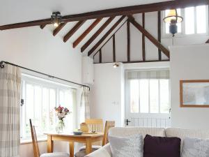a living room with a couch and a table at Stable Cottage in Icklesham