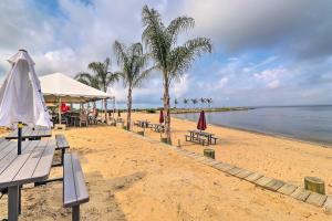 a beach with benches and umbrellas and the ocean at Walk to the Beach with Deck, Fireplace, BBQ Grill, Boat Ramp & Office in Chestertown