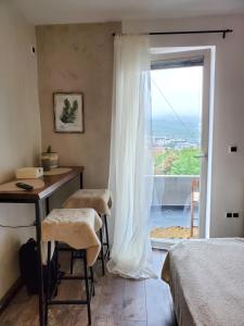 een slaapkamer met een bed, een bureau en een raam bij Sleep and drive cosy in Sarajevo