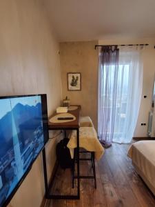 een kamer met een bureau en een groot televisiescherm bij Sleep and drive cosy in Sarajevo