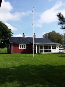 una casa rossa con una bandiera nel cortile di Orsastuguthyrning-Hansjö a Orsa