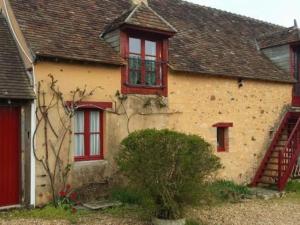 ein altes Haus mit roten Fenstern und einer Treppe in der Unterkunft Gîte Asnières-sur-Vègre, 2 pièces, 3 personnes - FR-1-410-152 in Asnières-sur-Vègre