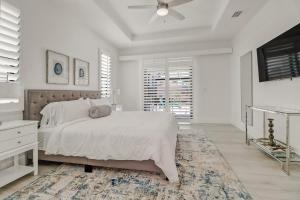 una camera da letto bianca con un letto e un ventilatore a soffitto di The Twins Villa a Cape Coral Altre 11 foto