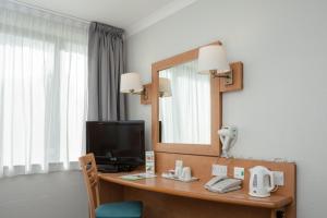 a bathroom with a sink, mirror and a television at Campanile Hotel Dartford in Dartford