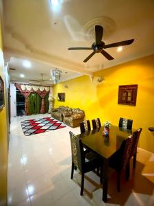 a living room with a table and a ceiling fan at Idaman Sinar Homestay in Nibung Tebal