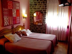 a bedroom with two beds and a window at Hostal Casa La Picota in Cofiñal +27 photos